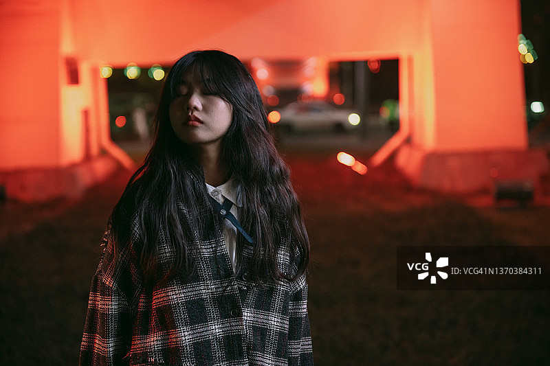 夜晚霓虹灯下的年轻亚洲女孩们图片素材