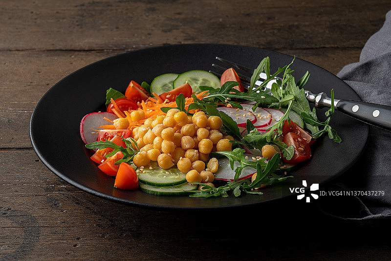 纯素植物沙拉，芝麻菜、小萝卜片、鹰嘴豆、黄瓜、西红柿和胡萝卜图片素材