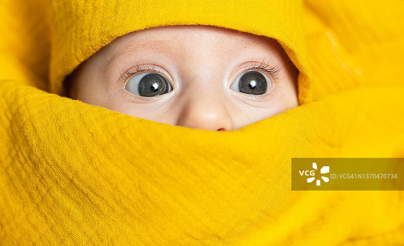 包裹在黄色襁褓中的婴儿面部图片素材