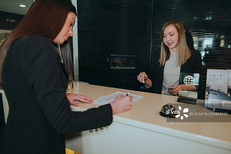 女商人在酒店前台办理入住图片素材