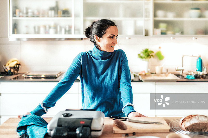 站在厨房料理台前的女人图片素材
