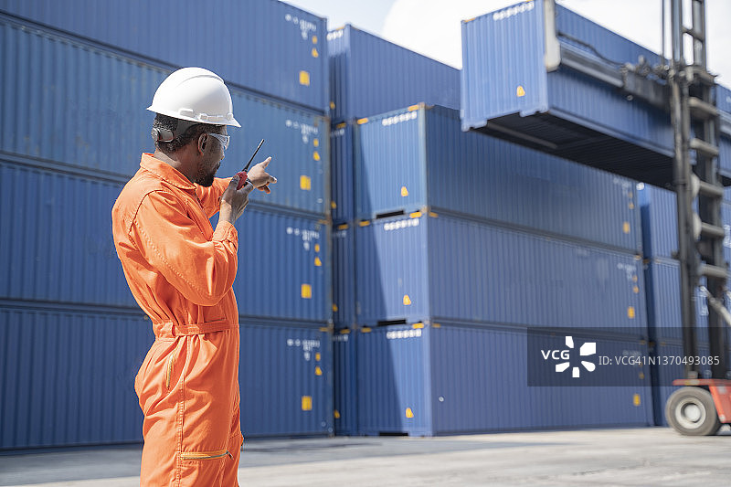 智能工程师工头控制从货运船上装载集装箱，用于进出口图片素材