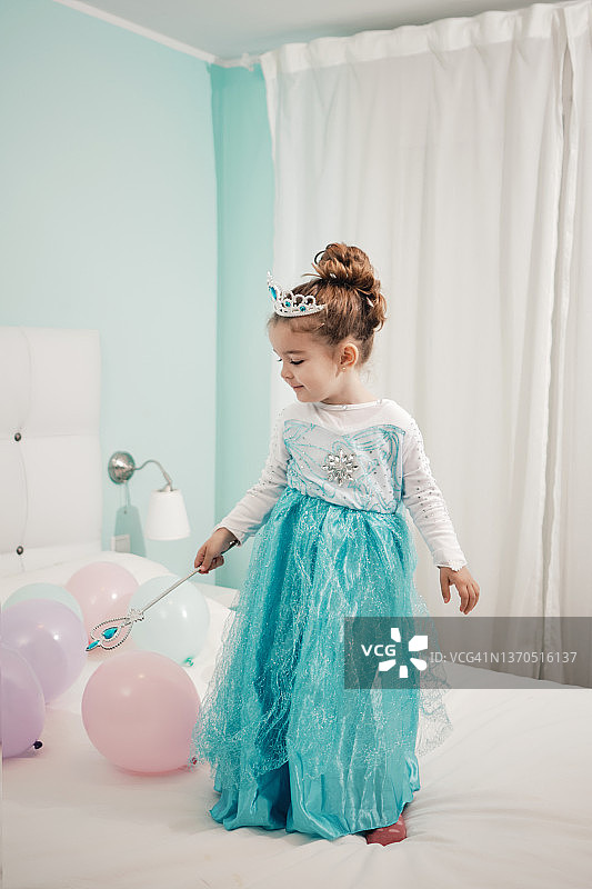 装扮成公主在床上玩气球的小女孩图片素材