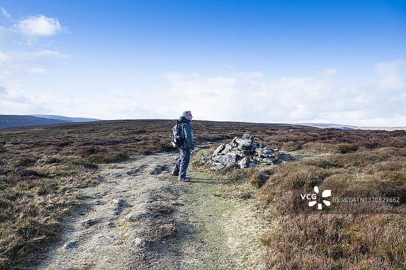 在英国威尔士蒙茅斯郡小路上的年长的白人男子，背着背包眺望远方图片素材