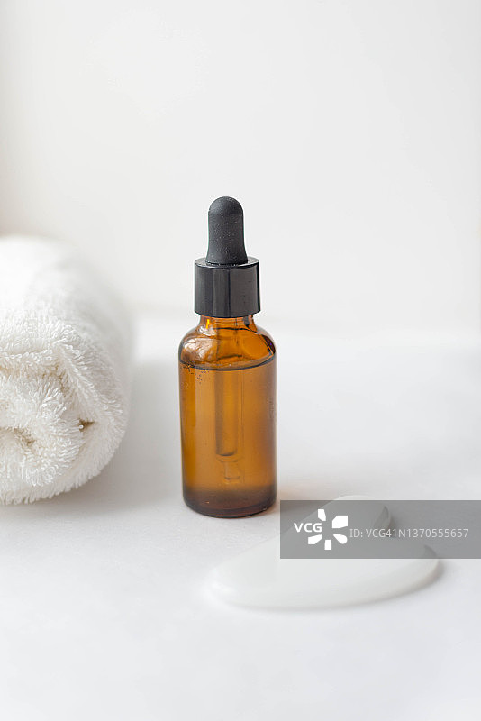 玻璃罐中的天然化妆品套装、白色刮痧板和白色毛巾，呵护理念图片素材