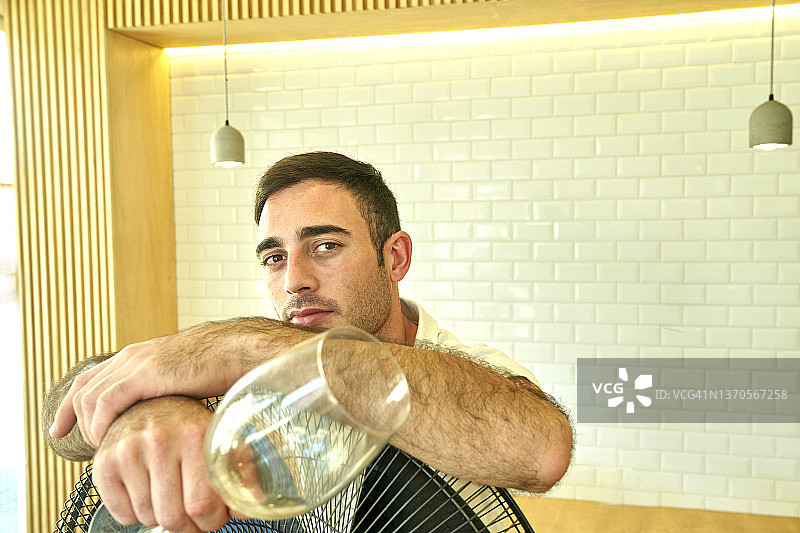 酒保的肖像。男人酒保拿着酒杯看着镜头的肖像图片素材