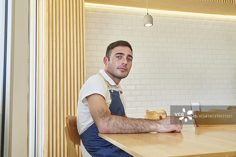 在酒吧柜台使用手机的微笑男人肖像图片素材