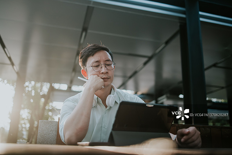 研究生在数字平板电脑上做论文作业图片素材