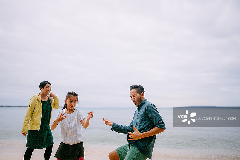 人们在黄昏时在海滩上雨中跳舞图片素材