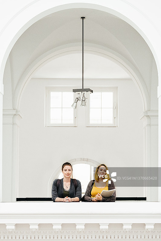 站在大学拱门下的两名学生图片素材