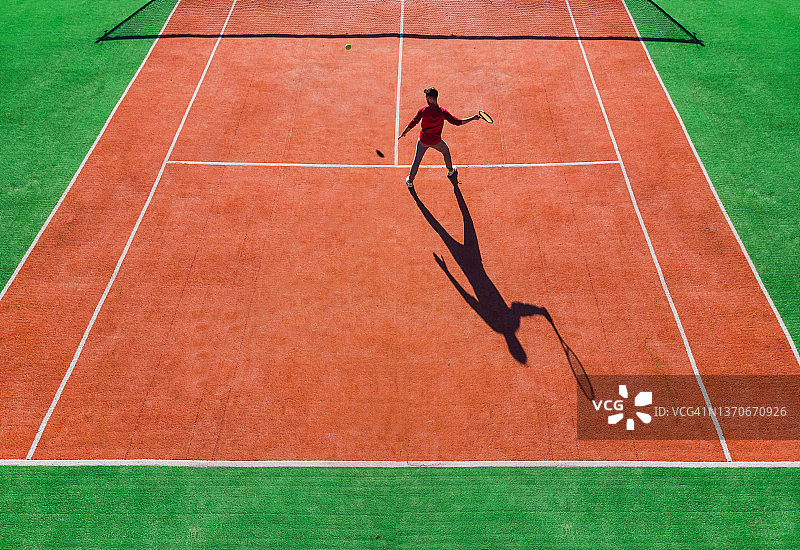 从上方拍摄的网球比赛无人机视角，可见球员的影子图片素材