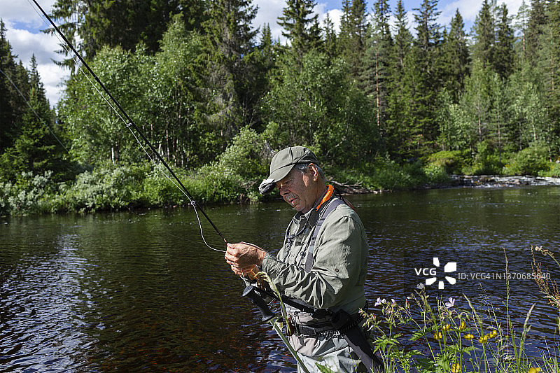 在河里钓鱼的男人图片素材