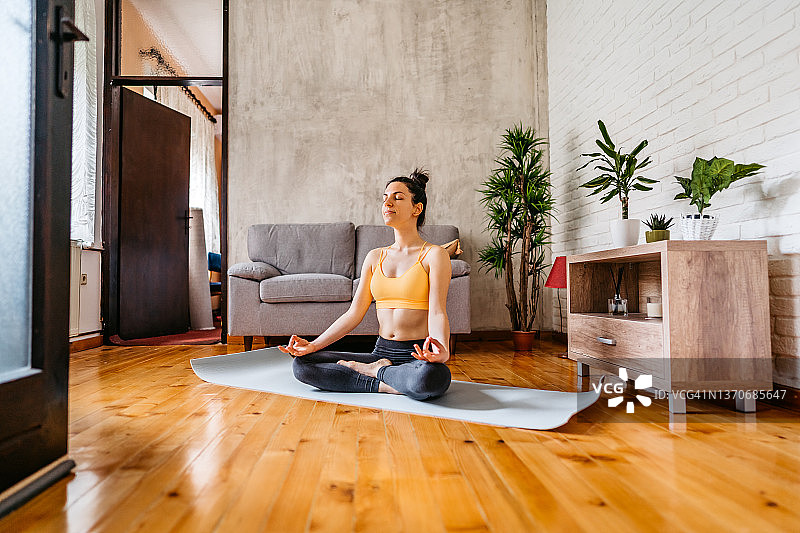 年轻女子练习莲花式瑜伽图片素材