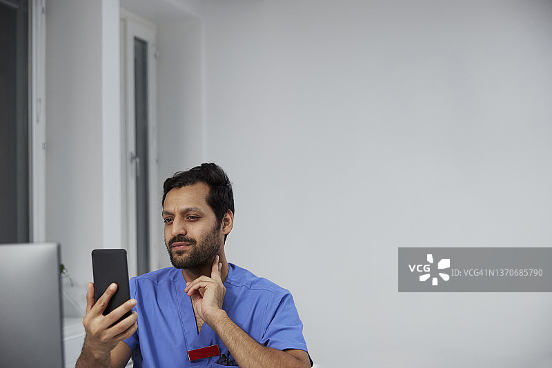 男医生用智能手机进行在线咨询图片素材