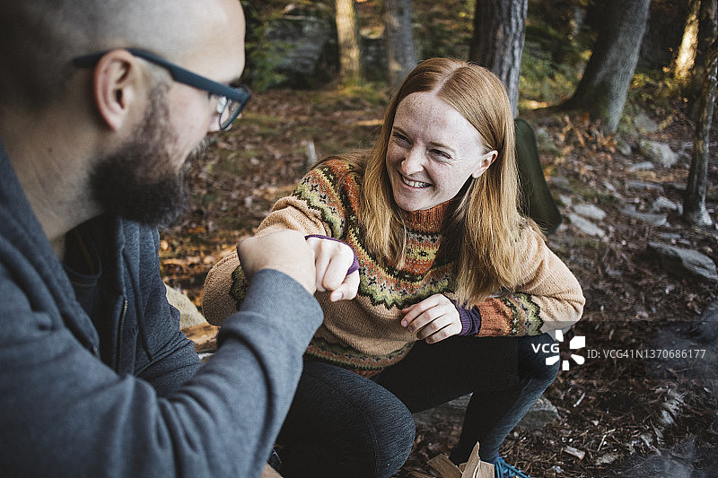 在森林里用拳头碰拳头的微笑情侣图片素材