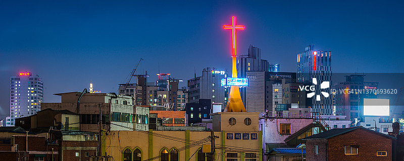 韩国首尔拥挤的摩天大楼城市景观中的霓虹灯十字架图片素材