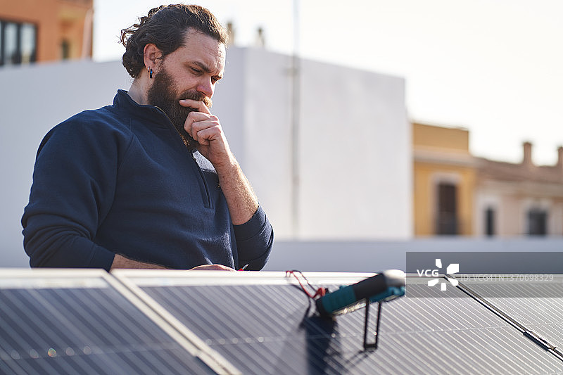 工人在太阳能电池板上使用万用表图片素材