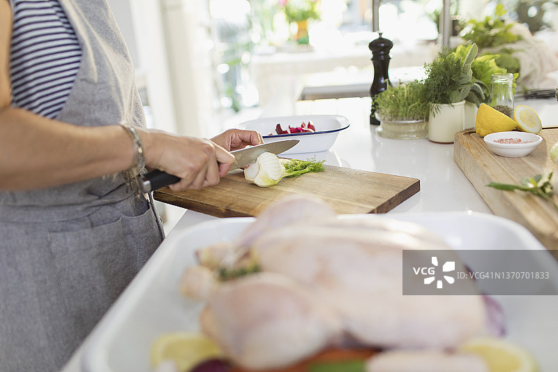 女人在厨房切草药准备烹饪鸡肉图片素材