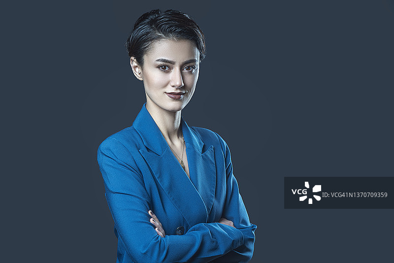 工作室半身像，一位美丽的短发女商人交叉双臂图片素材