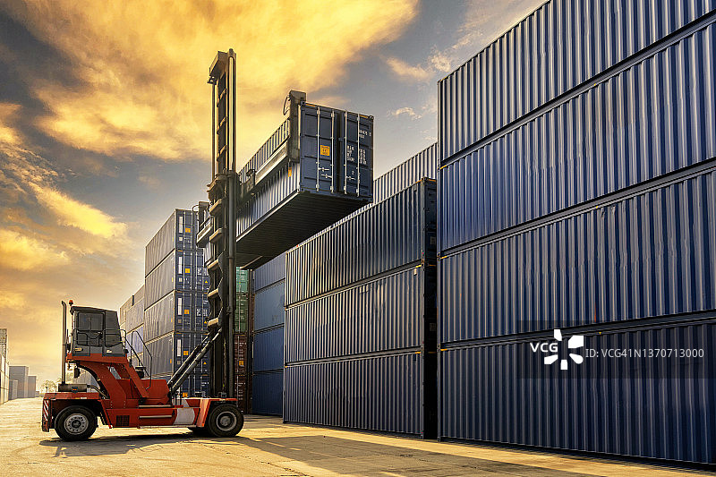 起重机和叉车在货运站吊装集装箱，物流业和货运业务概念图片素材