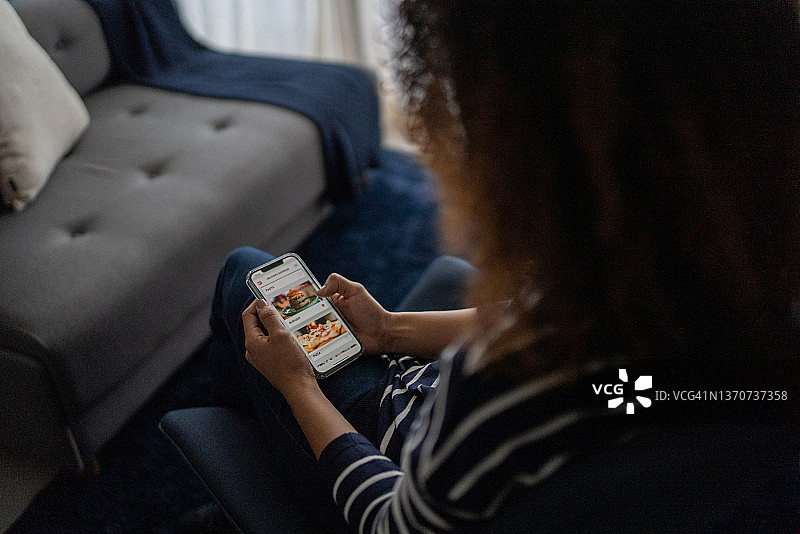 年轻女子在家用智能手机在线订购食物图片素材