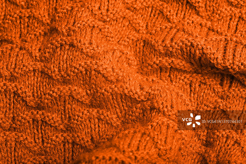 带有白色斑点的橙色针织纹理背景特写。潮流颜色。图片素材