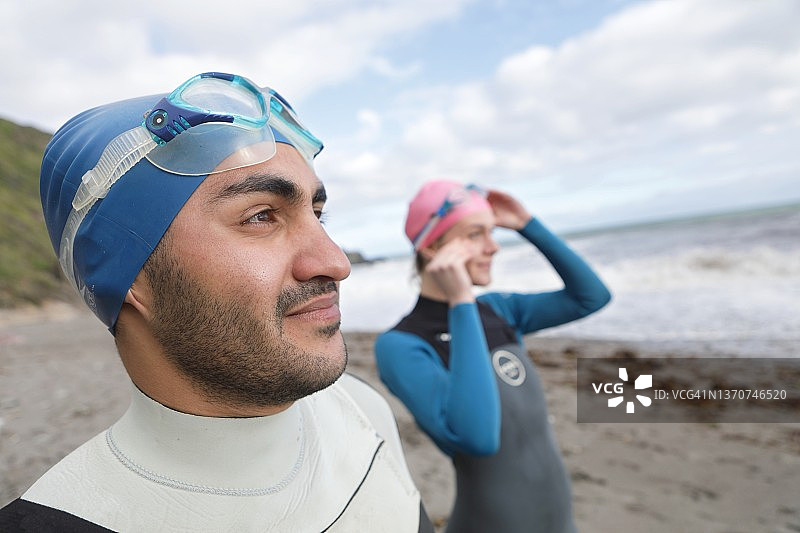 穿着泳装的年轻男人和女人看着大海图片素材