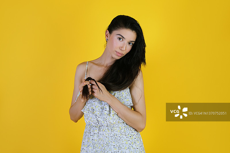穿着碎花裙的年轻女人手持头发图片素材