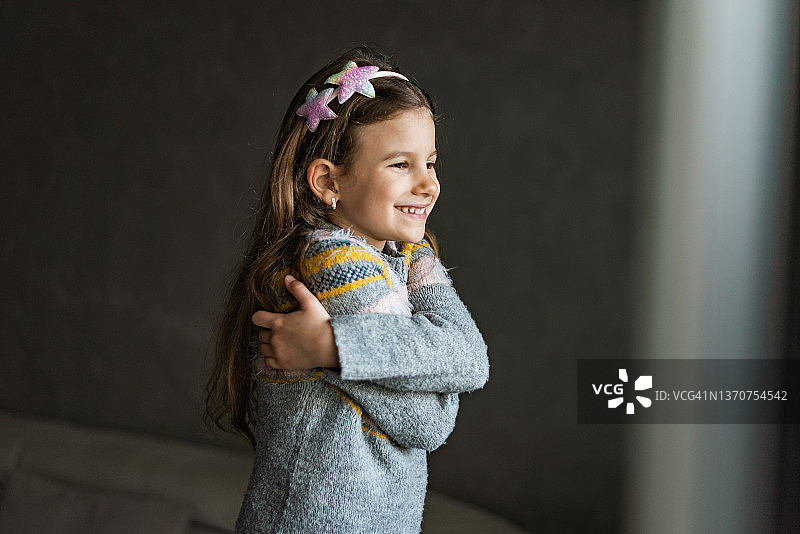 面带微笑，充满爱意的年轻女孩拥抱自己图片素材