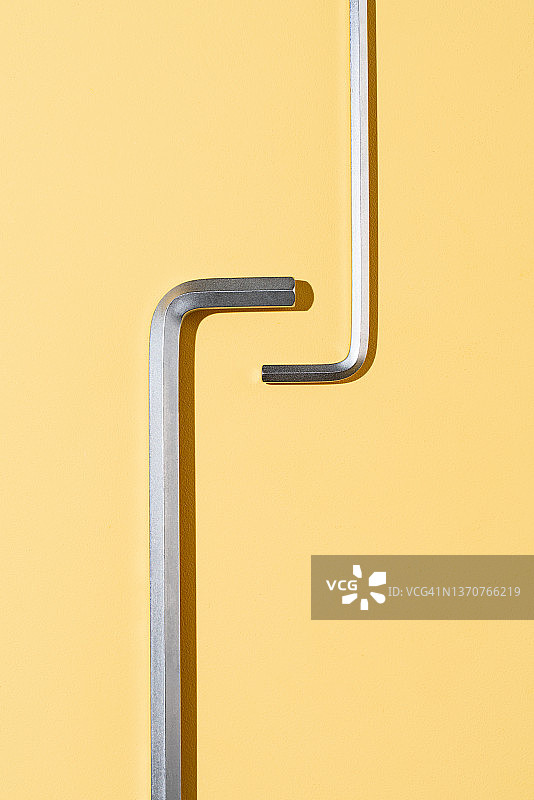 两把六角扳手在黄色背景上交错图片素材