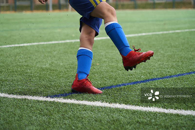 男孩穿着足球鞋和运动服在白天球场上图片素材