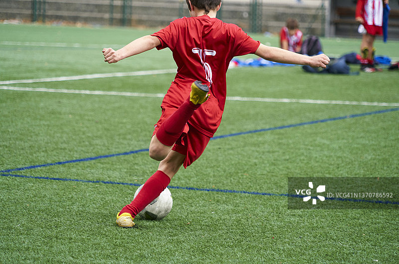 男孩在赛季最后一场比赛的足球场上踢球图片素材