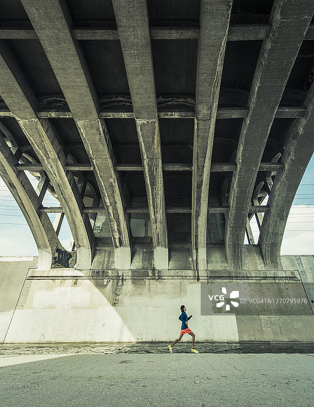 男子在城市桥下奔跑图片素材