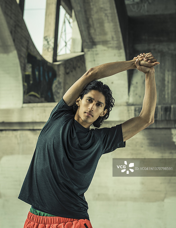 男人在城市桥下拉伸图片素材