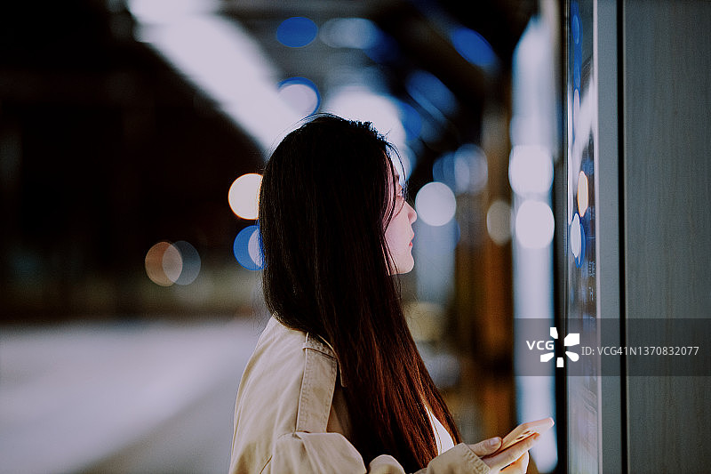 年轻的亚洲女性在车站使用触摸屏查询信息图片素材