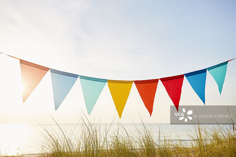 日落时分海边派对装饰的彩色三角旗/小旗链图片素材