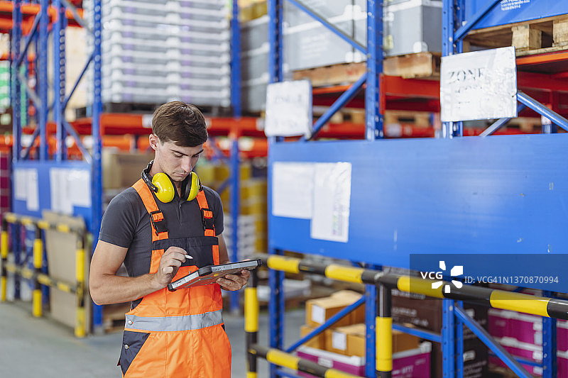 男仓库工人使用平板电脑在工厂仓库工作图片素材
