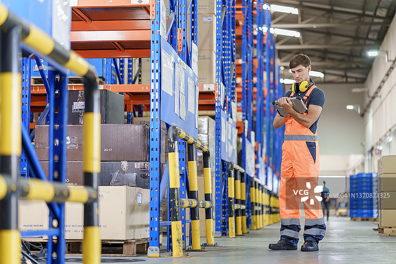 男仓库工人使用平板电脑在工厂仓库工作图片素材