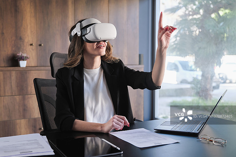在家中佩戴VR头显主持商务会议的商务女性图片素材