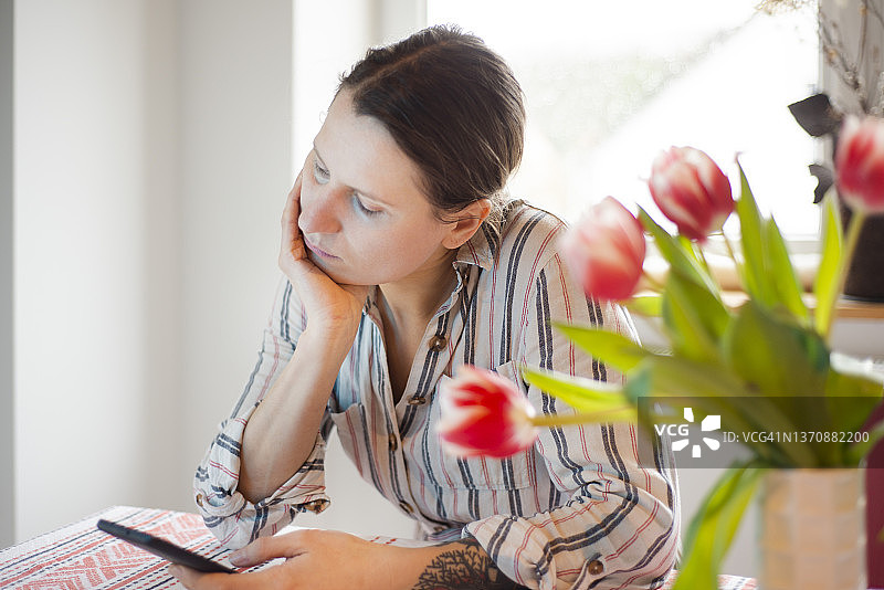 一位30多岁的女人整天在家玩手机图片素材