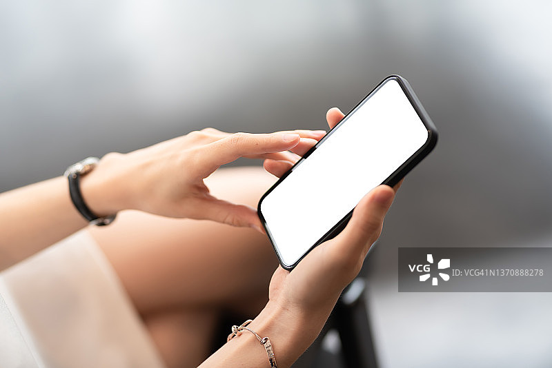 女人手持空白白色屏幕智能手机模型图片素材