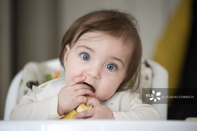 宝宝在高脚椅上吃香蕉图片素材