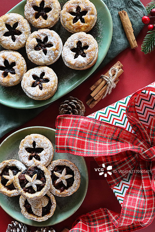 特写：圣诞肉馅饼，格子带圣诞礼物，肉桂，松果图片素材