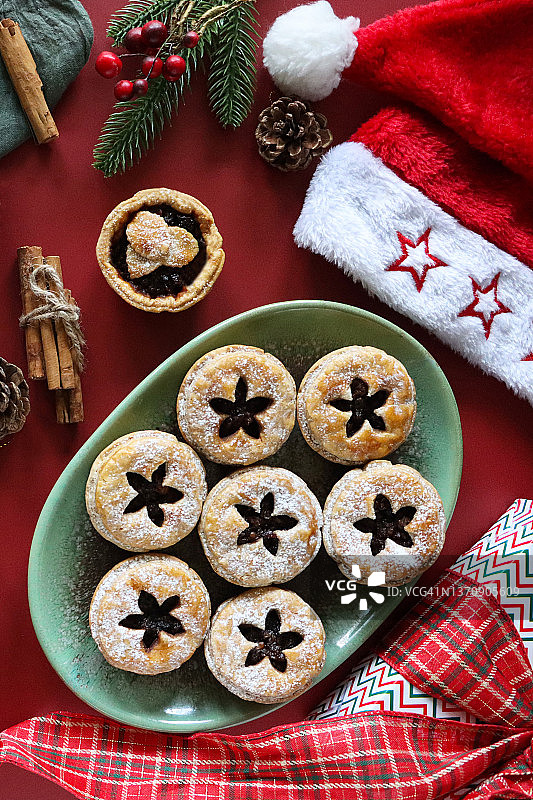 红色背景下圣诞肉馅饼与礼物特写图片素材