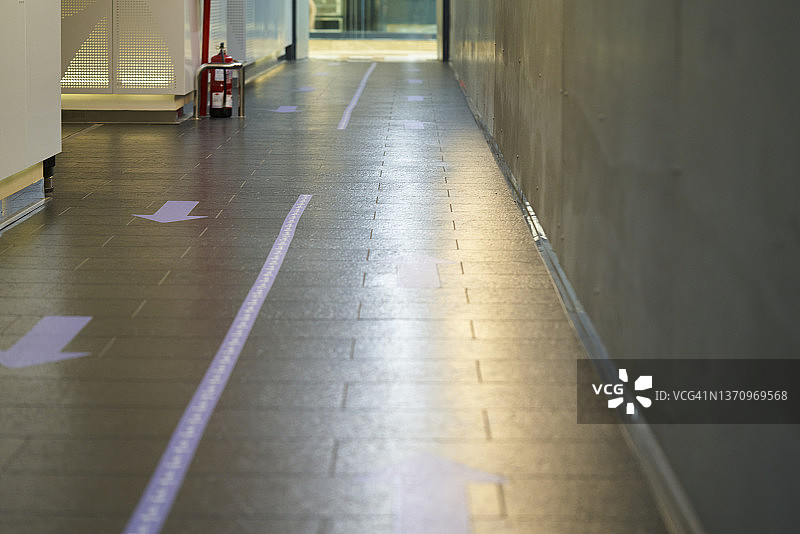 购物中心应急出口走廊，地面有指示行走方向的标识图片素材