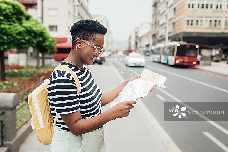 使用城市地图观光的年轻非裔美国女游客图片素材