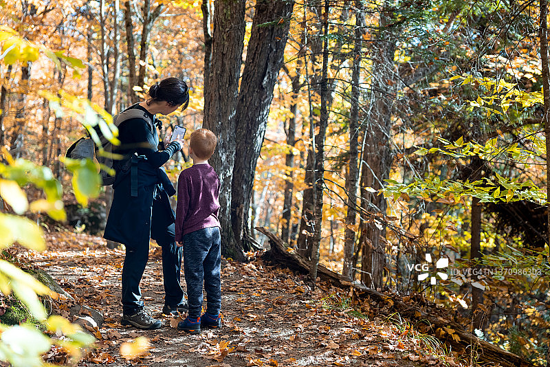在加拿大魁北克翠湖山国家公园秋季徒步旅行的可爱红发男孩和母亲图片素材