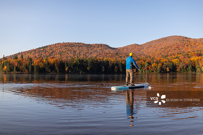 男人在魁北克省翠湖山国家公园的湖上划桨图片素材