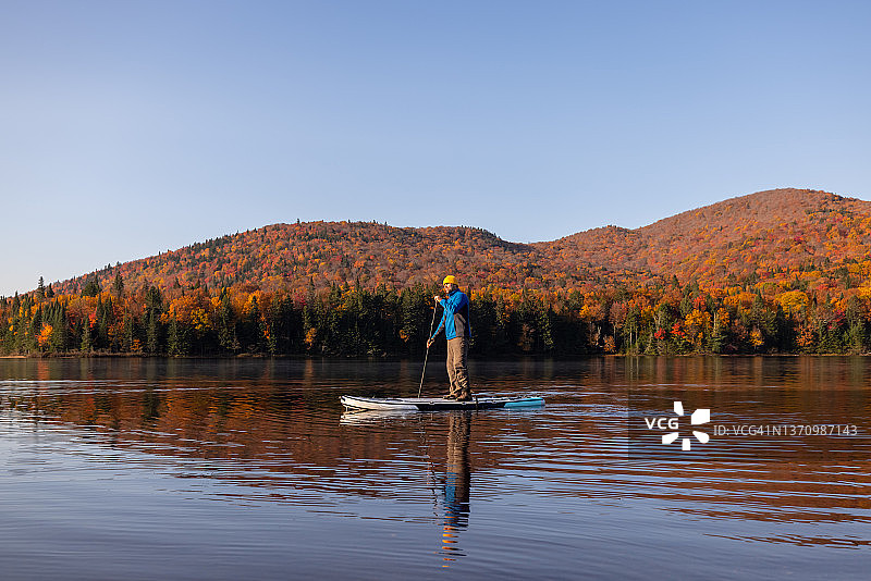 男人在魁北克省翠湖山国家公园的湖上划桨图片素材