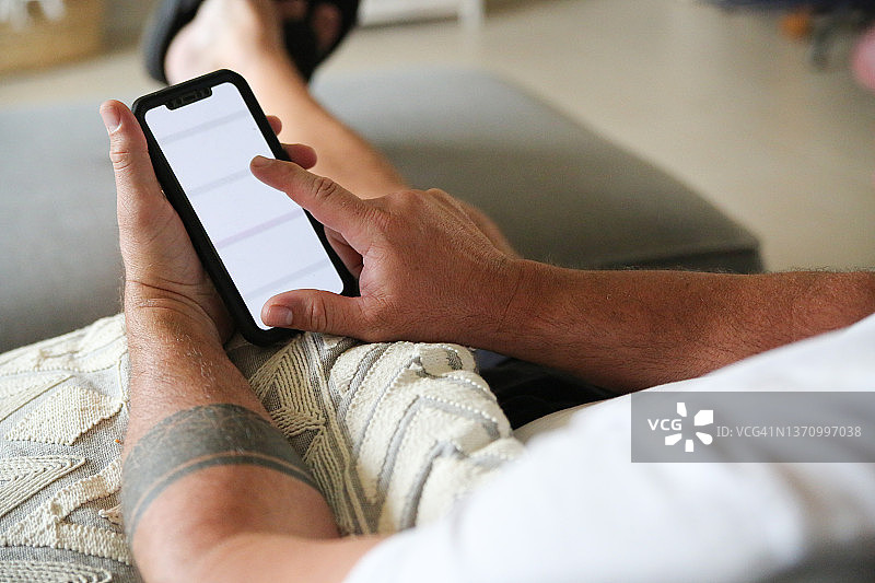 男人在沙发上看手机图片素材